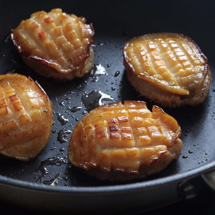 Golden-brown grilled abalone in a pan, highlighting its succulent texture and savory taste. Ideal for seafood lovers and gourmet cooking