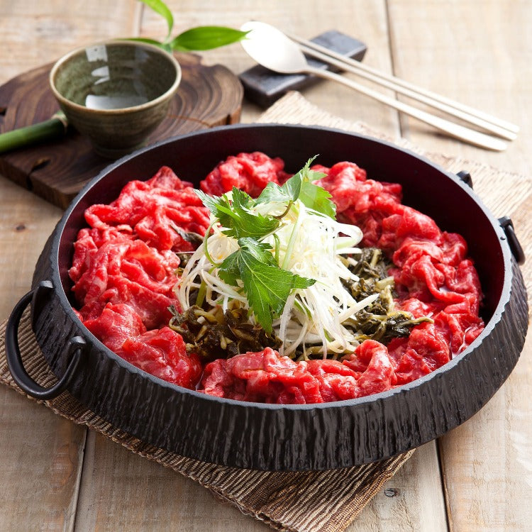 Sliced beef ribeye arranged in a pan with vegetables, ready for cooking. Perfect for hotpot, sukiyaki, or other gourmet beef dishes