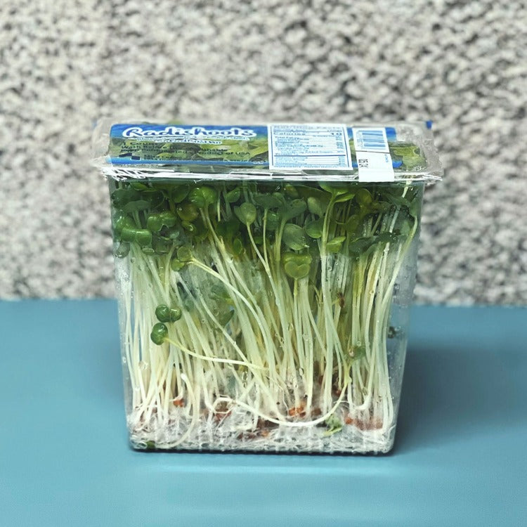 Package of fresh kaiware (radish sprouts) in a plastic container, displaying nutrition facts and product label
