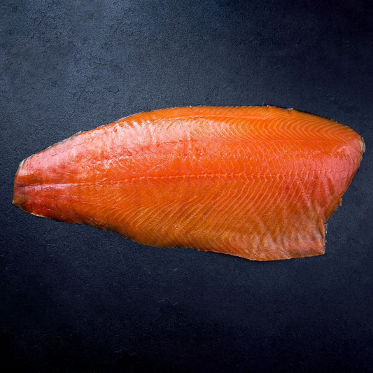 Whole smoked Atlantic salmon fillet on a dark surface, showcasing its texture and color