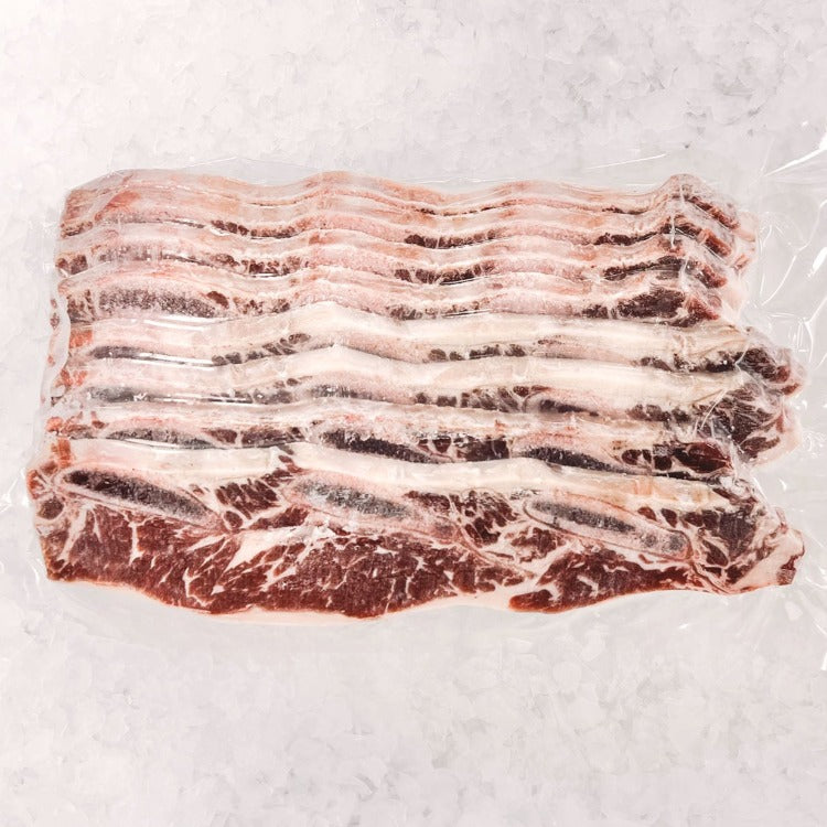 Frozen LA beef short ribs in vacuum-sealed packaging on ice