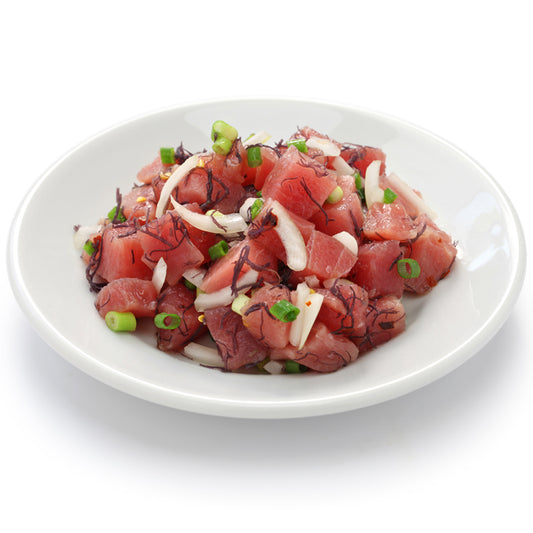 A plate of seasoned yellowfin tuna poke, with finely chopped scallions, diced onions, and light seasoning, served in a simple white bowl, emphasizing a healthy and flavorful seafood option