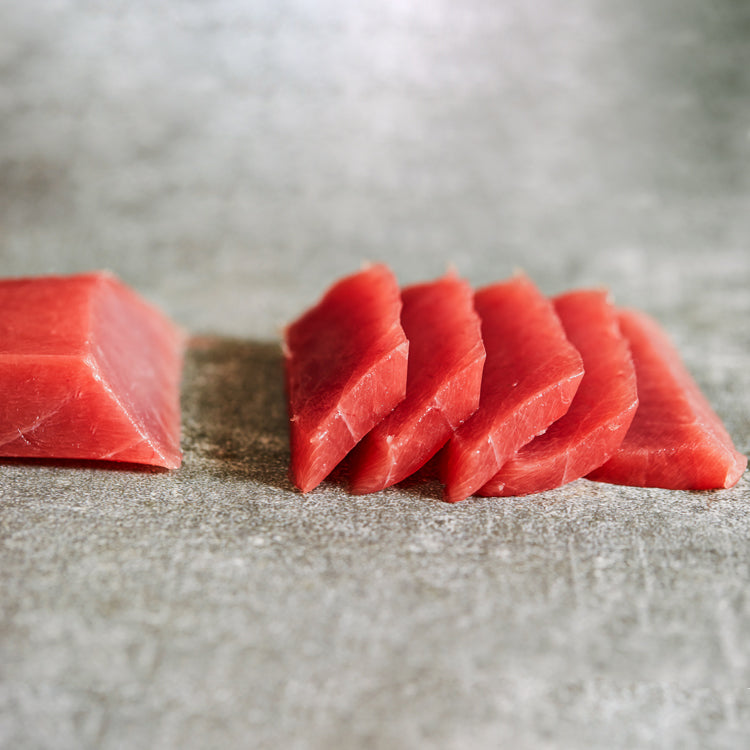 Slices of Yellowfin Tuna loin cut, highlighting the deep red color and perfect texture, ideal for sashimi or sushi preparations.