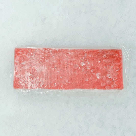 Frozen Yellowfin Tuna loin cut, vacuum-sealed for freshness and ready for slicing into sashimi or sushi, displayed on a bed of ice.