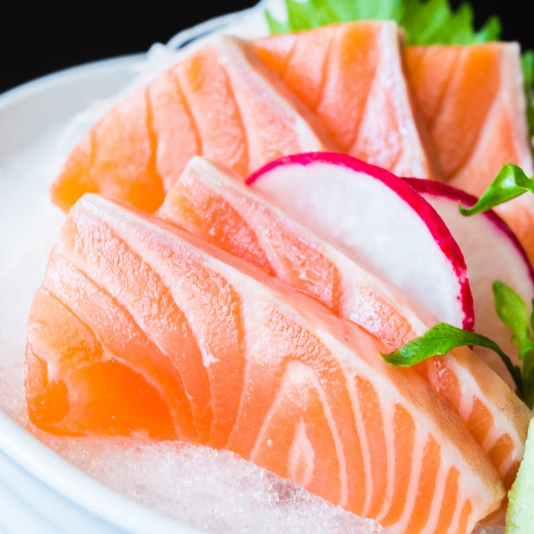 Close-up of fresh salmon sashimi slices garnished with radish and greens. Perfect for sushi and sashimi lovers, highlighting the rich, vibrant color and marbling of the salmon