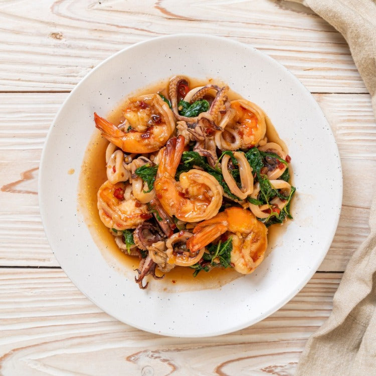 Shrimp Salad with Boiled Eggs, Lettuce, and Scallions on a White Plate