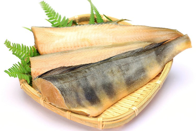Fresh Atka mackerel fillets displayed on a basket with green ferns, ready for cooking and presentation