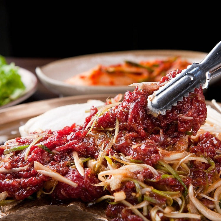 Close-up of raw marinated beef bulgogi mixed with onions and green onions, ready to be cooked. Perfect for an authentic Korean BBQ experience
