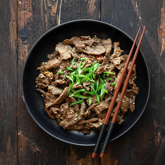 Cooked beef bulgogi served in a bowl, garnished with green onions and sesame seeds. A delicious Korean dish perfect for family meals and gatherings