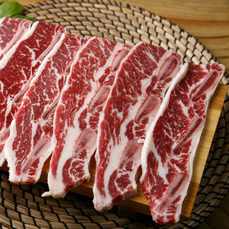 Fresh LA beef short ribs arranged neatly on a wooden board