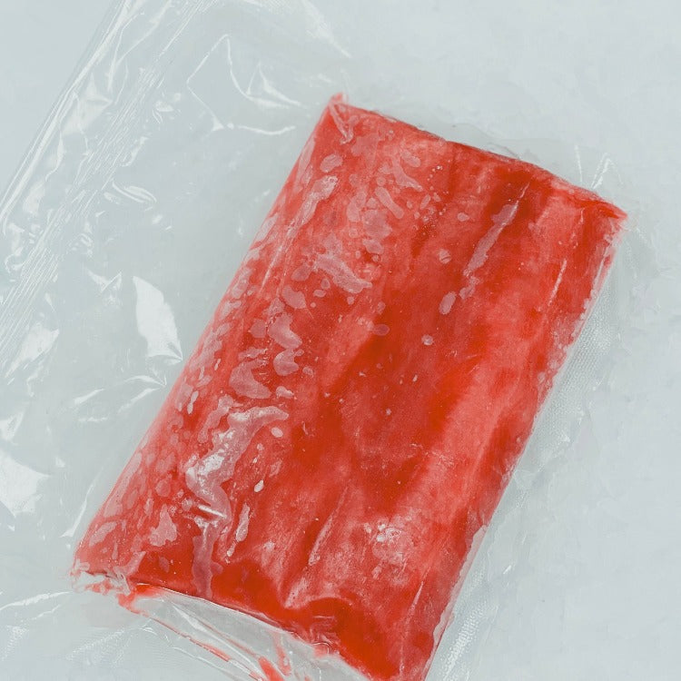 Frozen Bluefin Tuna loin cut, vacuum-sealed and displayed on a bed of ice, highlighting the vibrant red color and premium quality.