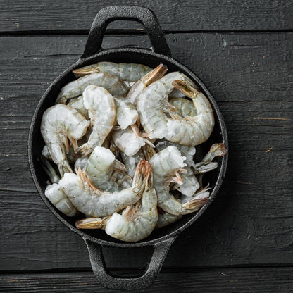 Frozen white shrimp in a black cast iron pot, ready for cooking