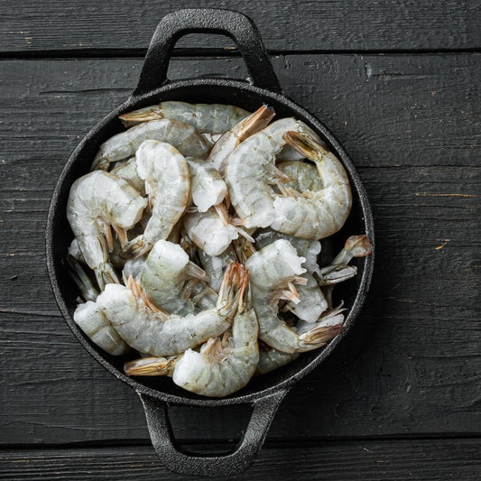 Frozen white shrimp in a black cast iron pot, ready for cooking